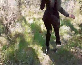 Walking on the wood wearing a black dress pantyhose heels