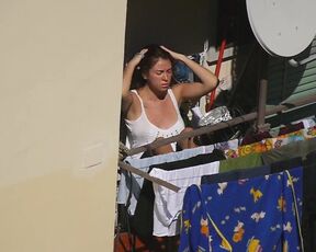 Busty girl enjoying the sun on the balcony