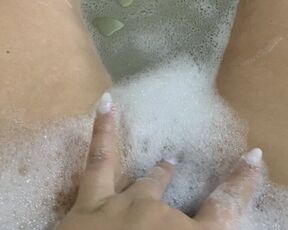 Horny babe masturbating during a bubble bath