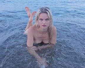 Blonde natural girl swimming naked in public beach